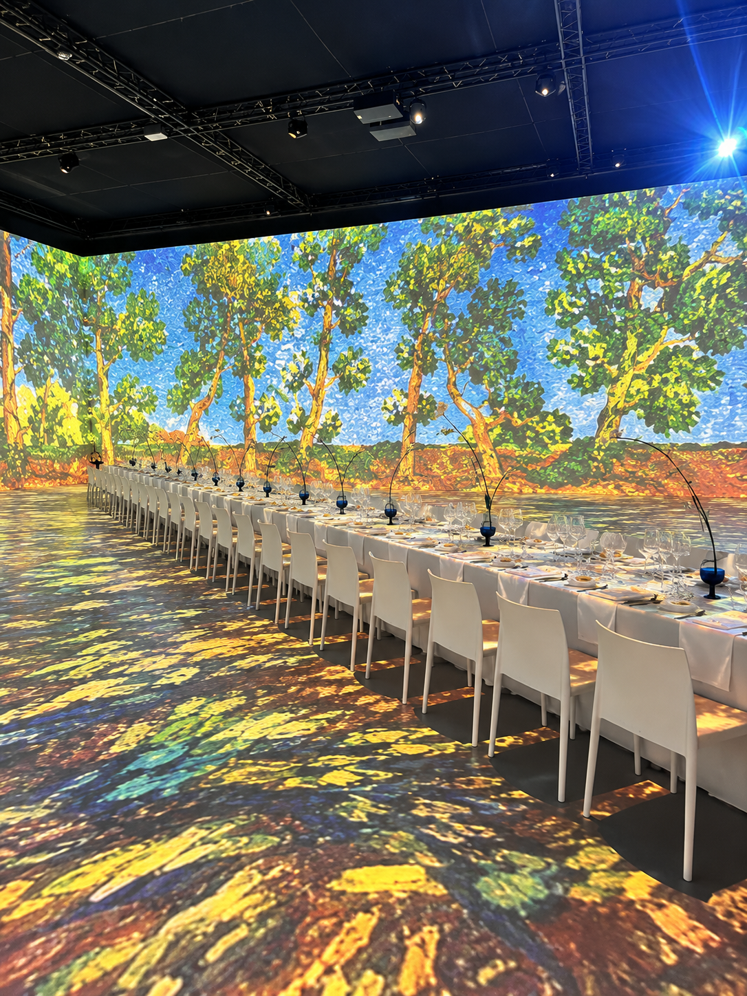 Dîner événementiel autour d'une grande table dans un décor immersif